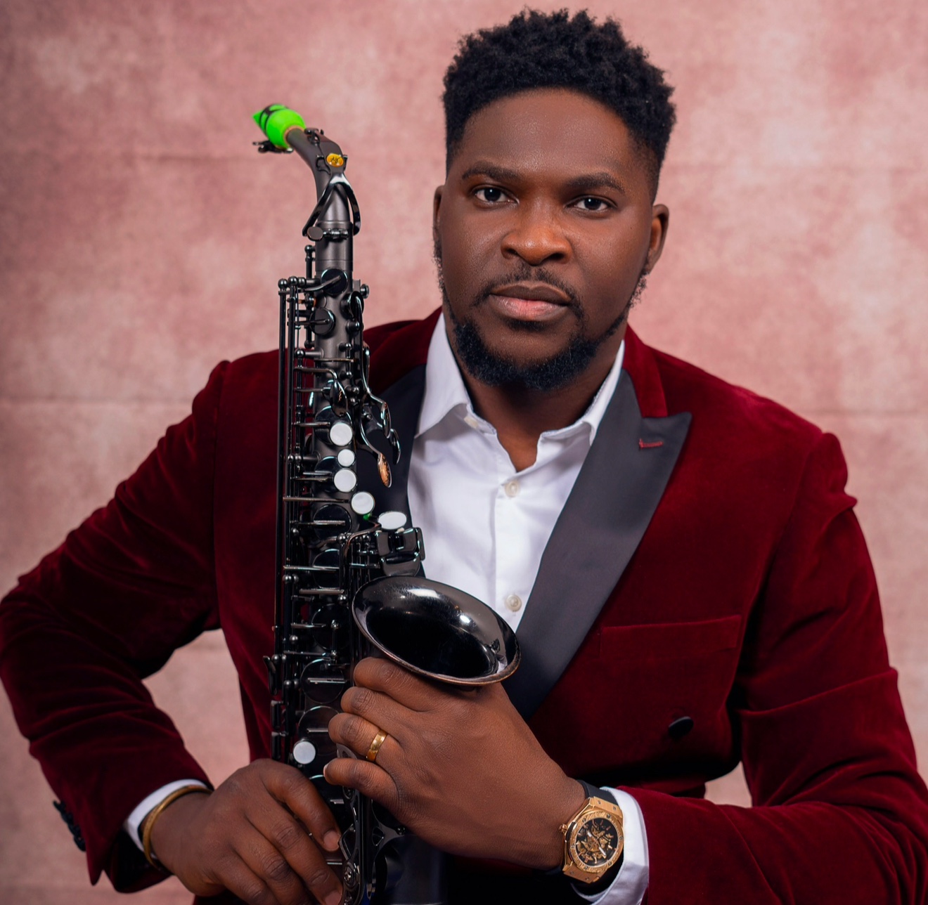 YomiSax in burgundy holding his saxophone